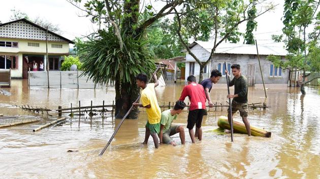 Young boys using banana rafts to cross flood water at Darangiri in Goalpara, Assam, May 26, 2020.(ANI) Young boys using banana rafts to cross flood water at Darangiri in Goalpara, Assam, May 26, 2020.(ANI)