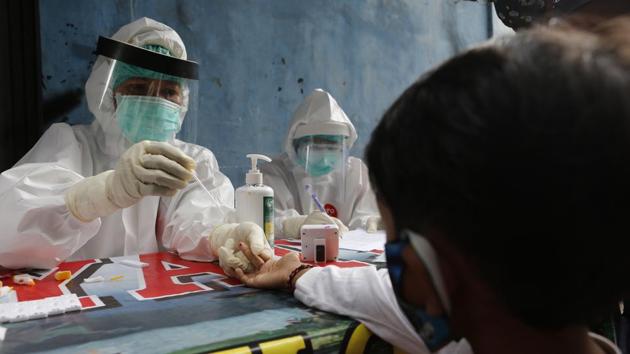 A boy waits to receive a coronavirus antibody test from health workers at a village in Bali, Indonesia, Wednesday, May 27, 2020. (AP Photo/Firdia Lisnawati)(AP)