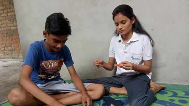 Deeksha and her brother Himanshu (above) and Aneesha and her brother Anmol (left) busy making sanitary pads.(HT Photo) Deeksha and her brother Himanshu (above) and Aneesha and her brother Anmol (left) busy making sanitary pads.(HT Photo)