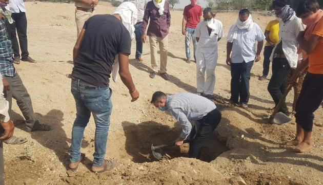 Kareda SDO Mahipal Singh digging the grave in Chhavandi village on Thursday.(HT Photo) Kareda SDO Mahipal Singh digging the grave in Chhavandi village on Thursday.(HT Photo)