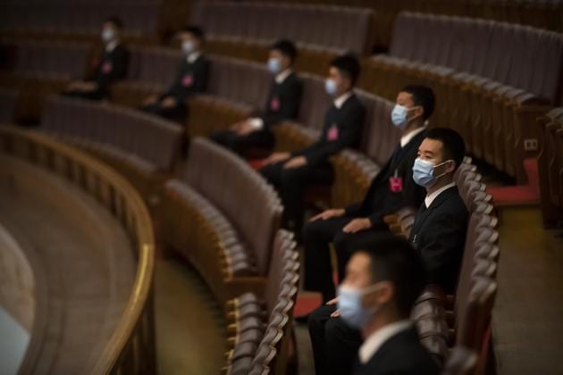 Security personnel wearing face masks to protect against the new coronavirus sit before the closing session of China's National People's Congress (NPC) at the Great Hall of the People in Beijing.(AP) Security personnel wearing face masks to protect against the new coronavirus sit before the closing session of China's National People's Congress (NPC) at the Great Hall of the People in Beijing.(AP)