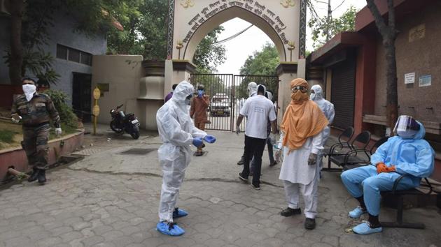 Health workers in PPE coveralls during the funeral rites of a person who died of Covid-19 at Nigambodh Ghat crematorium. “The bodies come wrapped in PPE suits. No one is allowed to open the suit. A worker at the furnace and one from the hospital put it in the furnace without removing the suit. We follow this process for all positive as well as suspected cases,” Vishal, a worker at the Nigambodh Ghat told HT. (Sonu Mehta / HT Photo) Health workers in PPE coveralls during the funeral rites of a person who died of Covid-19 at Nigambodh Ghat crematorium. “The bodies come wrapped in PPE suits. No one is allowed to open the suit. A worker at the furnace and one from the hospital put it in the furnace without removing the suit. We follow this process for all positive as well as suspected cases,” Vishal, a worker at the Nigambodh Ghat told HT. (Sonu Mehta / HT Photo)
