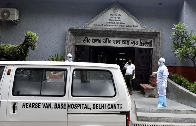 Health workers in PPE coveralls during the funeral rites of a person who died of Covid-19, at Nigambodh Ghat crematorium in New Delhi. On May 26, eight bodies were returned from the Nigambodh Ghat CNG crematorium because the facility was in no position to accept more bodies for disposal. Only two of the six furnaces were working at the crematorium. (Sonu Mehta / HT Photo) Health workers in PPE coveralls during the funeral rites of a person who died of Covid-19, at Nigambodh Ghat crematorium in New Delhi. On May 26, eight bodies were returned from the Nigambodh Ghat CNG crematorium because the facility was in no position to accept more bodies for disposal. Only two of the six furnaces were working at the crematorium. (Sonu Mehta / HT Photo)