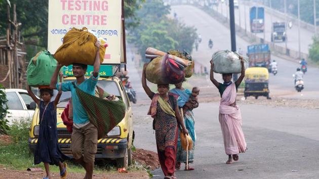 Migrants with their belongings walk along the national highway road during coronavirus lockdown, in Bhubaneswar last week.(ANI Photo) Migrants with their belongings walk along the national highway road during coronavirus lockdown, in Bhubaneswar last week.(ANI Photo)