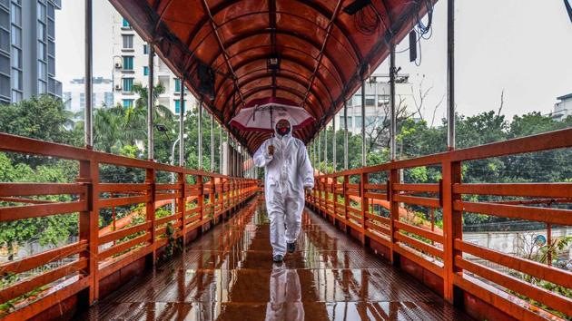A man wearing protective gear as a preventive measure against the Covid-19 coronavirus walks over a footbridge in Dhaka on May 27, 2020. ((AFP photo) A man wearing protective gear as a preventive measure against the Covid-19 coronavirus walks over a footbridge in Dhaka on May 27, 2020. ((AFP photo)