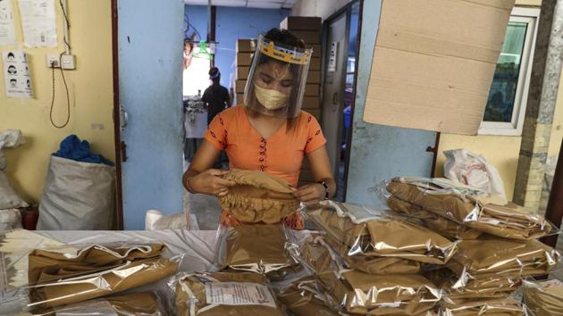 A woman wearing face mask and face shield to help curb the spread of the new coronavirus, checks surgical gown at a packing session at a garment factory Thursday, May 28, 2020, at Industrial Zone in Yangon, Myanmar.(AP) A woman wearing face mask and face shield to help curb the spread of the new coronavirus, checks surgical gown at a packing session at a garment factory Thursday, May 28, 2020, at Industrial Zone in Yangon, Myanmar.(AP)