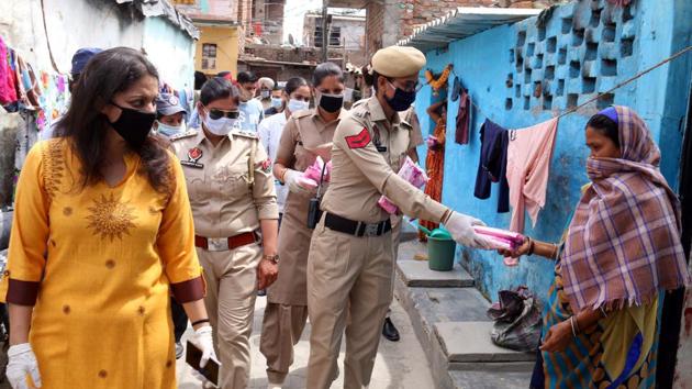 Punjab police cops distributing sanitary napkins to women amid curfew to stop the spread of Coronavirus in Bathinda . (Sanjeev Kumar/Hindustan Times)