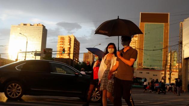 People wear protective masks as they cross a street following an outbreak of the coronavirus disease in Beijing, China on May 28.(Reuters Photo) People wear protective masks as they cross a street following an outbreak of the coronavirus disease in Beijing, China on May 28.(Reuters Photo)