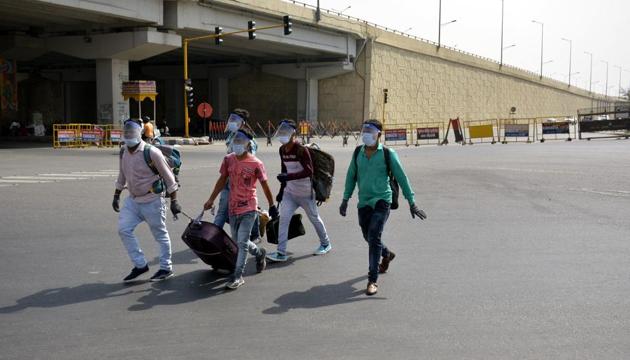 People wearing face shields walk past police barricades at UP Gate along the Delhi-Uttar Pradesh border in Ghaziabad on Thursday(Sakib Ali/HT Photo) People wearing face shields walk past police barricades at UP Gate along the Delhi-Uttar Pradesh border in Ghaziabad on Thursday(Sakib Ali/HT Photo)