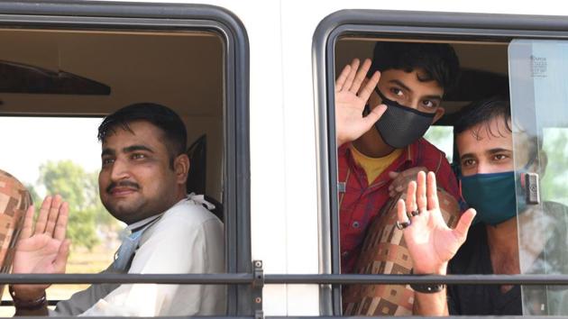 Pakistani nationals, who were stranded in India following the closure of borders due to Covid-19 lockdown, wave goodbye before crossing the Wagah border post, on May 27.(AFP Photo) Pakistani nationals, who were stranded in India following the closure of borders due to Covid-19 lockdown, wave goodbye before crossing the Wagah border post, on May 27.(AFP Photo)