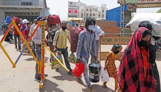 Migrant workers and their families standing in a queue wait for buses to move towards the railway station to board a train to their home state Bihar, during nationwide lockdown to slow the spreading of the coronavirus disease (COVID-19), in Ahmedabad on May 22/ representative.(ANI)