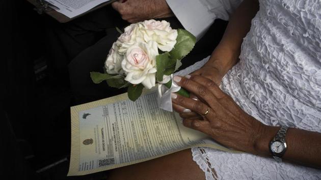 A bride holds a bouquet during her drive-thru wedding. Because most states have prohibited large gatherings in their effort to curb the spread of the virus, many Brazilians have been forced to delay traditional wedding ceremonies or seek safe alternatives. (Silvia Izquierdo / AP)