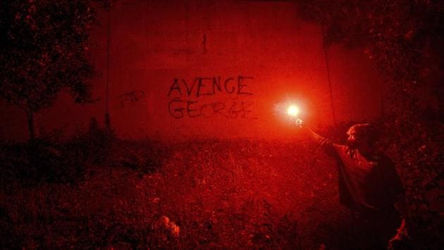 In this May 29 photo, a demonstrator holds a flare in Oakland, California while protesting the death of George Floyd, a handcuffed black man in police custody in Minneapolis. Chauvin, the officer who knelt on Floyd’s neck, was fired on May 26, along with three other officers involved in the arrest. (Noah Berger / AP) In this May 29 photo, a demonstrator holds a flare in Oakland, California while protesting the death of George Floyd, a handcuffed black man in police custody in Minneapolis. Chauvin, the officer who knelt on Floyd’s neck, was fired on May 26, along with three other officers involved in the arrest. (Noah Berger / AP)