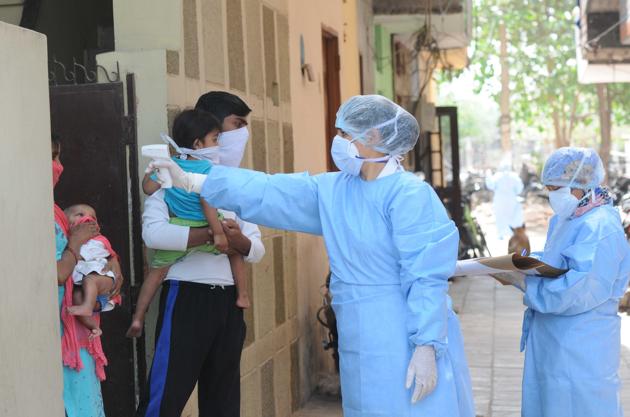 A health worker checks people in a sealed area as Covid-19 cases spike in Chandigarh’s Bapu Dham Colony.(Keshav Singh/Hindustan Times)