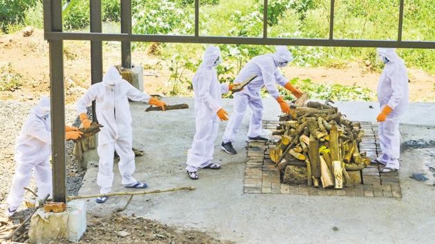 Municipal workers wearing protective suits cremate the body of Covid-19 victim in Karad, Maharashtra.(PTI)