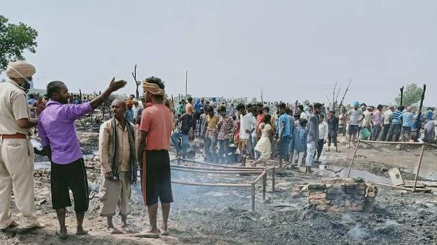 Cops inspecting the site where a fire broke out, destroying several shanties in Ludhiana on Friday.(HT PHOTO)