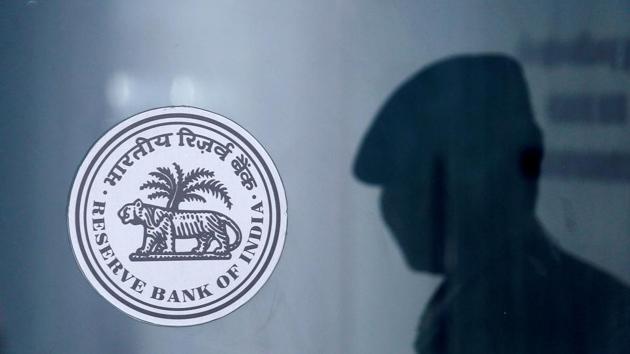 A security guard's reflection is seen next to the logo of the Reserve Bank Of India at the RBI headquarters in Mumbai.(REUTERS) A security guard's reflection is seen next to the logo of the Reserve Bank Of India at the RBI headquarters in Mumbai.(REUTERS)