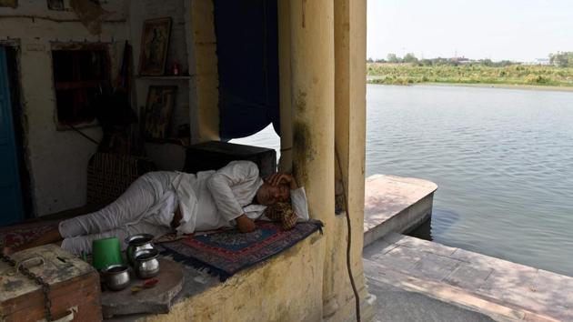 A priest takes an afternoon nap outside a small temple on the banks of the Yamuna river in New Delhi on May 28. In Delhi, the sprawling national capital of around 20 million people, the demand for water outstrips supply by an estimated 760 million litres per day, as reported by AFP. (Prakash Singh / AFP) A priest takes an afternoon nap outside a small temple on the banks of the Yamuna river in New Delhi on May 28. In Delhi, the sprawling national capital of around 20 million people, the demand for water outstrips supply by an estimated 760 million litres per day, as reported by AFP. (Prakash Singh / AFP)