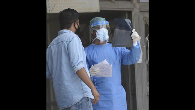 A medical professional examines an X-ray report outside at Lok Nayak Jai Prakash Narayan (LNJP) Hospital. Over the last two days, the Delhi government earmarked 1,900 beds in three hospitals -- 200 in Satyawadi Raja Harish Chandra Hospital, 200 in Deep Chand Bandhu Hospital, and all 1500 beds in Guru Teg Bahadur Hospital. This is in addition to the 2,500 beds at LNJP Hospital and Rajiv Gandhi Superspeciality Hospital. (Vipin Kumar / HT Photo)