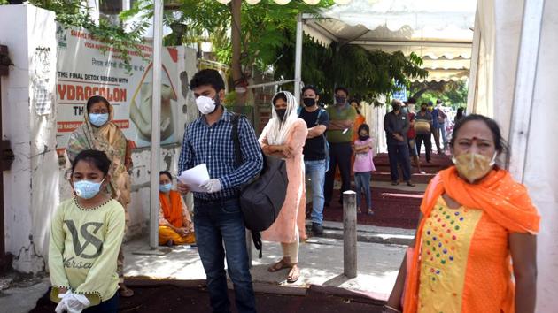 People stand in queue to get screened for coronavirus, at SPPC Hospital in Vinod Nagar New Delhi on Saturday.(Sushil Kumar/HT Photo)