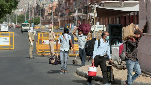 People carrying luggage pass barricades placed at the Ramganj coronavirus hotspot in Jaipur, Rajasthan.(Himanshu Vyas/ Hindustan Times) People carrying luggage pass barricades placed at the Ramganj coronavirus hotspot in Jaipur, Rajasthan.(Himanshu Vyas/ Hindustan Times)