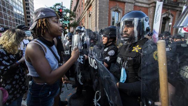 Demonstrators talk to police in riot gear.(AP)