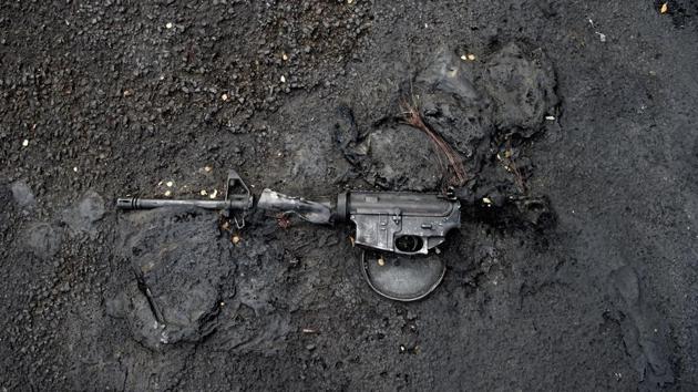 A rifle is seen melted into the pavement where a police car was also burnt outside the downtown library in Salt Lake City. Major US cities saw another night of violent protests on May 31-- cleaning up broken glass and burned out cars after curfews failed to stop confrontations between activists and law enforcement. (Jeremy Harmon / The Salt Lake Tribune via AP)