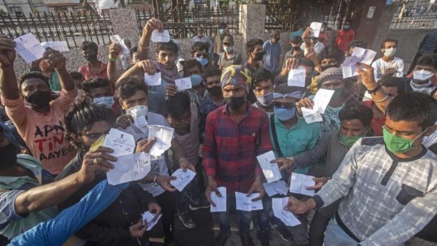 Migrants who were left behind show the tokens allotted to them on Saturday.(Pratham Gokhale/HT Photo)