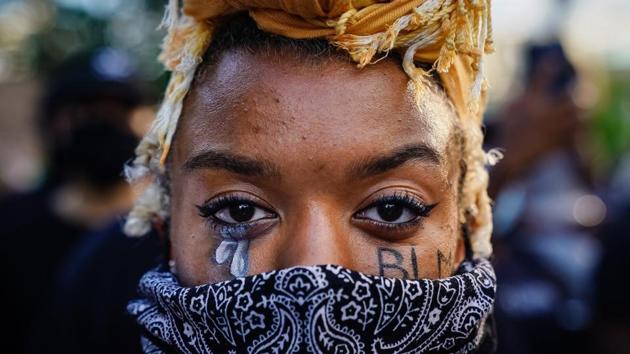 A woman with 'BLM (short for Black Lives Matter)' written on her cheek poses for a picture during a demonstration on May 31 in Atlanta, Georgia. The National Guard said on Sunday that 5,000 soldiers and airmen had been activated in 15 states and Washington, DC, but that “state and local law enforcement agencies remain responsible for security.” (Elijah Nouvelage / Getty Images / AFP)