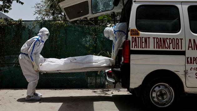 Mortuary workers load the body of a person who died from the coronavirus disease into an ambulance.While medical staff work tirelessly to save as many lives as possible, scenes of loss also play out in the same facility. Mourning relatives looked on, as the body bag was loaded into an ambulance and taken away to a cemetery. (Danish Siddiqui / REUTERS)