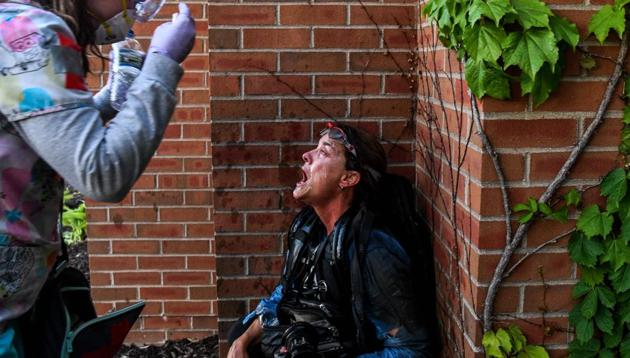 Medic protestor assists a member of the media after police started firing tear gas and rubber bullets near the 5th police precinct during a demonstration to call for justice for George Floyd, a black man who died while in custody of the Minneapolis police, on May 30, 2020.(AFP photo)