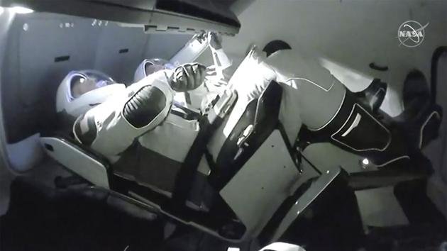 NASA astronauts Doug Hurley (L) and Robert Behnken are seen inside the Crew Dragon space capsule as they dock with the International Space Station. “It’s great to get the United States back in the crewed launch business, and we’re just really glad to be on board this magnificent complex,” Hurley said through mission control, reported Reuters. (NASA TV / AP)