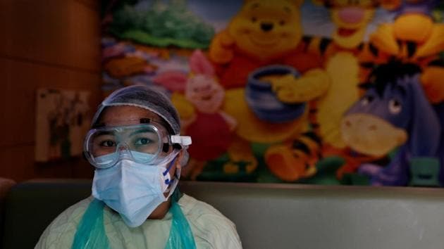 A medical worker takes a break in area that was designated for neonatal care, but is now a command centre for Covid-19 cases. Until a few months ago the cries of babies would often fill this section. Now, posters of Winnie the Pooh and other cartoon characters beam down upon patients struggling to beat a deadly virus. (Danish Siddiqui / REUTERS)