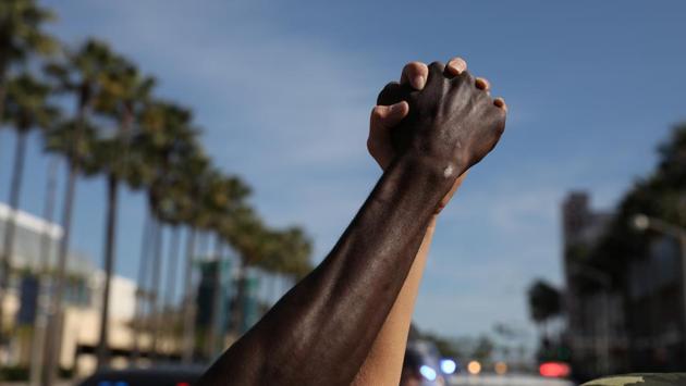 Protesters hold hands during as a nationwide unrest followed the death of George Floyd in Minneapolis police custody in Long Beach, California on May 31. Protesters have flooded streets after weeks of lockdown during the coronavirus pandemic that threw millions out of work and hit minority communities especially hard. (Patrick T. Fallon / REUTERS)