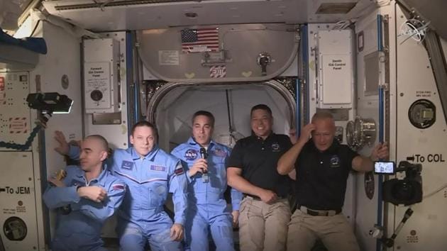 Astronauts Douglas Hurley (R) and Robert Behnken (2R) seen with the crew at International Space Station on May 31. The space station’s current crew welcomed them aboard with hugs and handshakes on schedule at 1:25 pm EDT, after executing a critical spacecraft docking milestone and kicking off the crew’s potentially months-long stay in the orbital laboratory. (NASA TV / AFP)