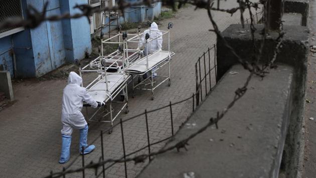 Hospital staff dressed in protective gear carry empty stretchers from a morgue towards a hospital in Mumbai, India, Friday, May 29, 2020. (AP photo) Hospital staff dressed in protective gear carry empty stretchers from a morgue towards a hospital in Mumbai, India, Friday, May 29, 2020. (AP photo)