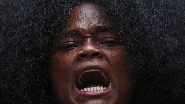 Ebri Yahloe, 26, protests while sitting along High Street on June 1 in Columbus, Ohio. Derek Chauvin, one of four Minneapolis police officers involved in George Floyd's arrest, has himself been arrested and charged with third-degree murder and manslaughter. During the arrest, video footage showed Chauvin kneeling on Floyd's neck for almost nine minutes as Floyd repeatedly said "I can't breathe." (Joshua A. Bickel / The Columbus Dispatch via AP)