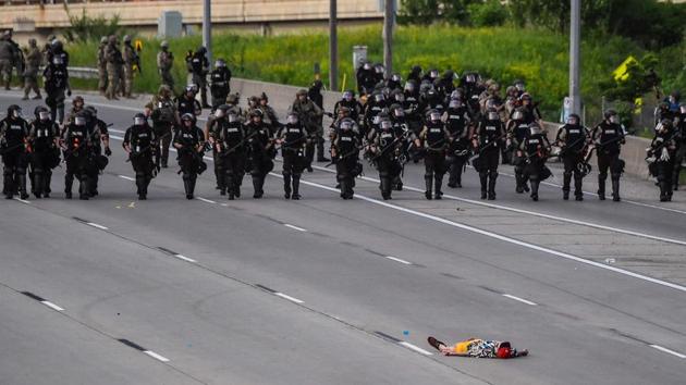 A demonstrator lies on the highway in front of the police line during a protest over the death of George Floyd on May 31 in Minneapolis, Minnesota. (CHANDAN KHANNA / AFP)