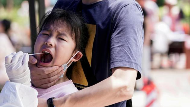 A child reacts while undergoing nucleic acid testing in Wuhan, the Chinese city hit hardest by the coronavirus disease (Covid-19) outbreak, Hubei province.(REUTERS)