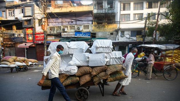 Workers transport sacks and parcels piled on top of a hand pushcart in Khari Baoli wholesale market in New Delhi, on Tuesday, June 2, 2020. (Amal KS/HT Photo) Workers transport sacks and parcels piled on top of a hand pushcart in Khari Baoli wholesale market in New Delhi, on Tuesday, June 2, 2020. (Amal KS/HT Photo)