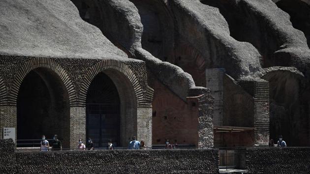 Visitors walk across the Colosseum monument. Officials told AFP that they had expected only 300 people -- a far cry from the thousands of tourists taking selfies who jam-pack the ancient stadium on a normal basis. (Filippo MONTEFORTE / AFP)