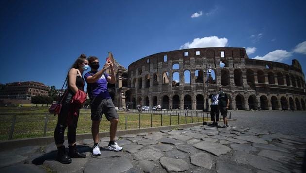 A couple take a picture in front of the Colosseum, which reopened to the public on June 1 after an extended closure in Rome. The Colosseum welcomed visitors after a three-month coronavirus lockdown but only a few hundred people were expected at Italy’s top tourism site. (Filippo MONTEFORTE / AFP)