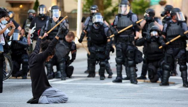 A protester on his knees puts his hands up during a standoff with police in front of the Georgia State Capitol during a protest against the death in Minneapolis in police custody of African-American man George Floyd, in Atlanta, Georgia, US.(Reuters)
