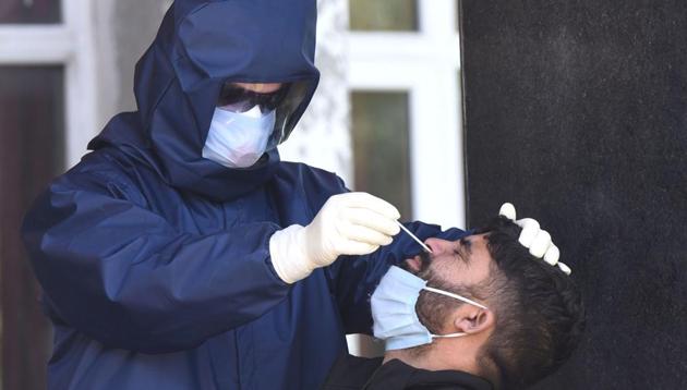 A medical staff collects sample from a man for Covid-19 tests at a quarantine centre at Zakura in Srinagar. (HT PHOTO) A medical staff collects sample from a man for Covid-19 tests at a quarantine centre at Zakura in Srinagar. (HT PHOTO)