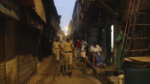 Police officials patrol in a lane during lockdown at the Dharavi slum, a Covid-19 hotspot in Mumbai. (AP) Police officials patrol in a lane during lockdown at the Dharavi slum, a Covid-19 hotspot in Mumbai. (AP)