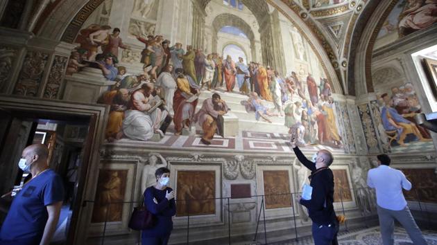Visitors admire "The School of Athens" fresco by Italian Renaissance artist Raphael inside the Vatican Museum. Museum director Barbara Jatta said that museum staff used the weeks of closure to ensure the safety of visitors as well as the art. “We want to share this patrimony but we want to share in safety,” she told AP. (Alessandra Tarantino / AP)