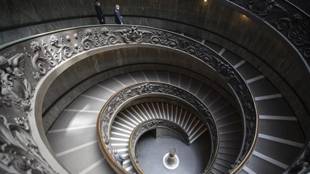Museum employees wearing masks walk down a staircase inside the Vatican Museum, designed by Giuseppe Momo in 1932. (Alessandra Tarantino / AP)
