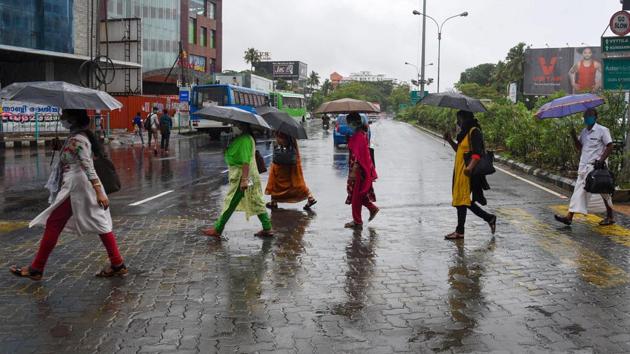 People under umbrellas walk on a road during rain, in Kochi on June 2, a day after the IMD officially announced the commencement of the four-month long rainfall season. (PTI)