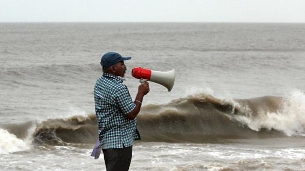 A Brihan Mumbai Corporation ( BMC) official makes an announcement at a sea facing promenade asking people to stay away from the sea in wake of Cyclone Nisarga in Mumbai. RK Jenamani, a senior scientist at the weather forecast department, said Cyclone Nisarga will gradually enter Mumbai and Thane districts. (ANI)