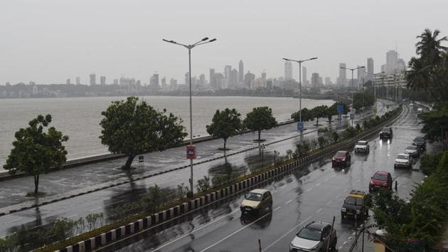 Commuters drive along Marine Drive as rain falls in Mumbai on June 3, 2020 as cyclone Nisarga barrels towards India's western coast.(AFP)